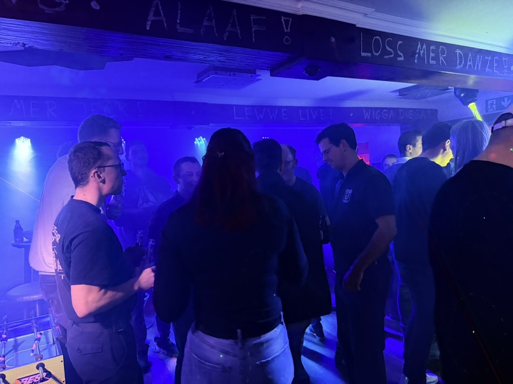 Gäste feiern im PitStop Club bei blauem Licht